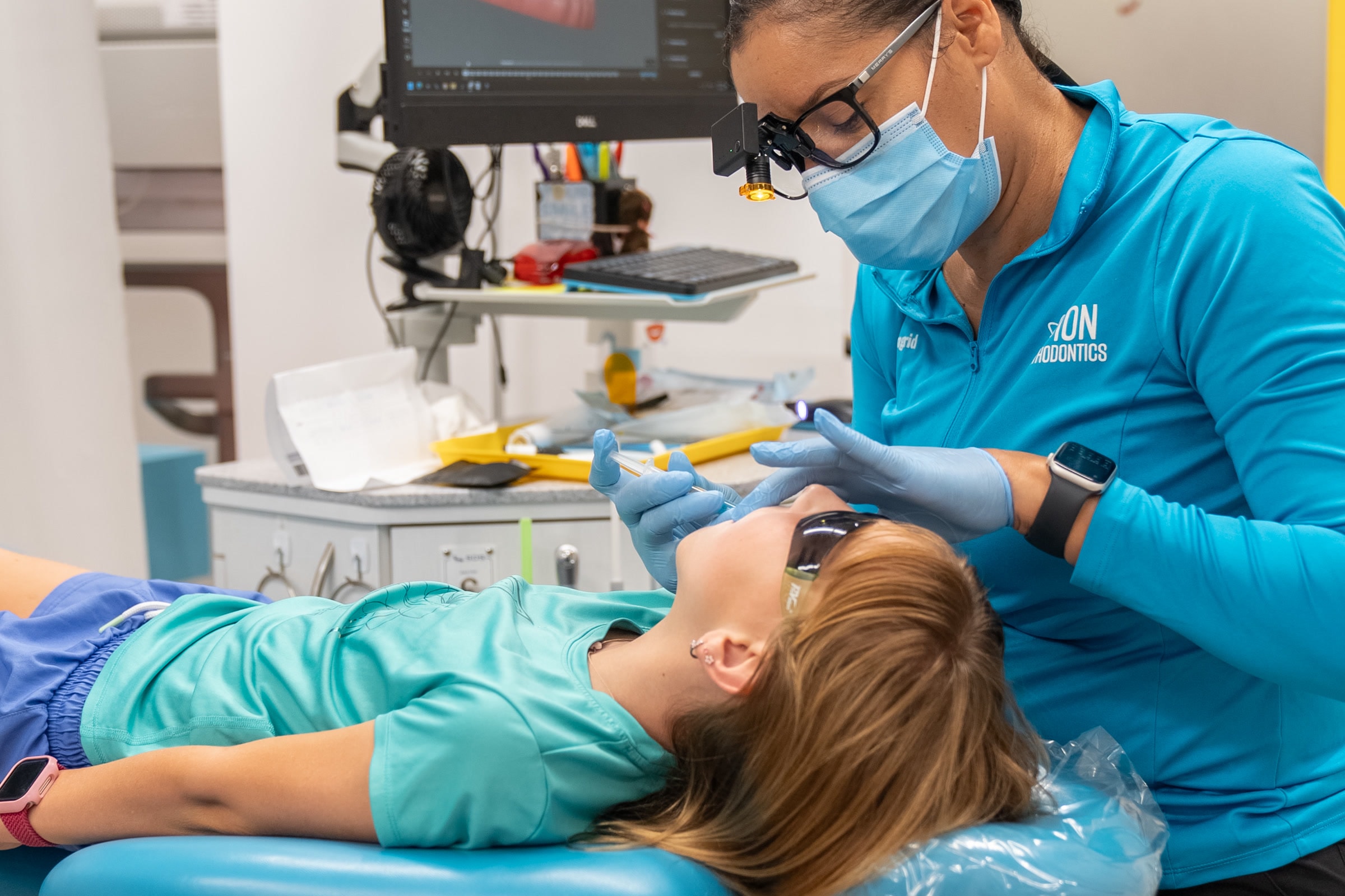 A clinician and young patient reviewing a panoramic x-ray during early treatment at ION Orthodontics in Port St. Lucie